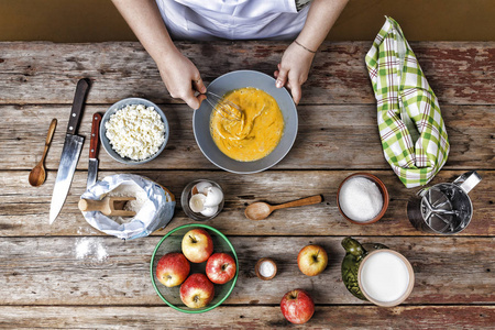 烹饪过程煎饼早餐.手搅拌面团的女孩.软焦点照片