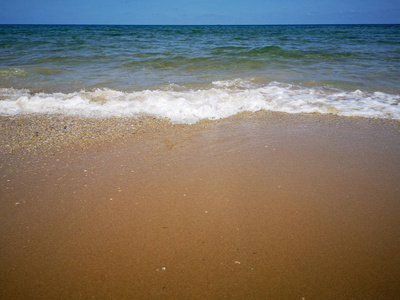 夏天的海滩和柔和的波浪过去。沙子和海