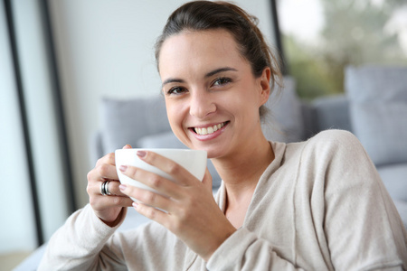 女人在家中休息，喝杯茶