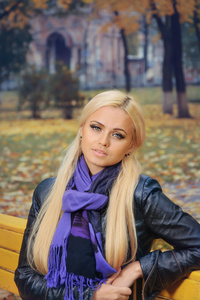 在秋天的公园里的紫色围巾的女孩