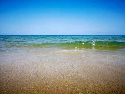 夏天的海滩和柔和的波浪过去。沙子和海