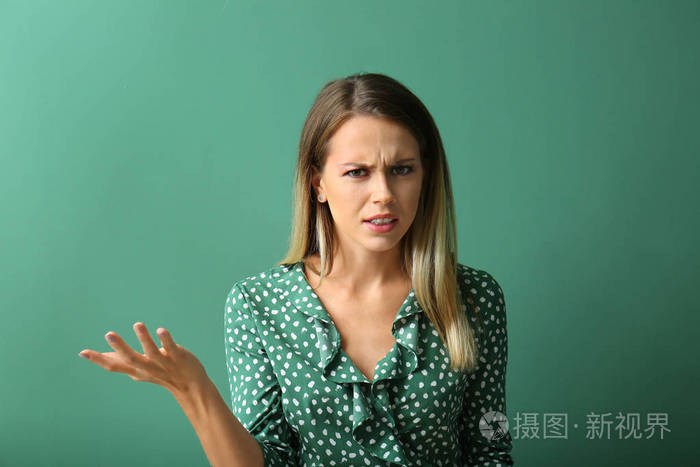 在颜色背景的愤怒的年轻妇女