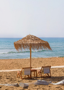 椅子和雨伞在科孚岛的海滩上