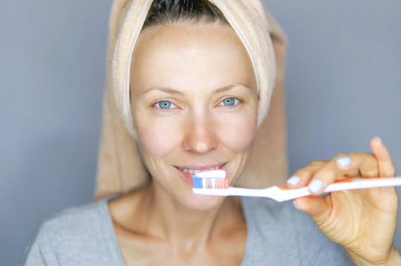 妇女刷牙清洁牙齿。晨例 带牙刷的女孩。口腔卫生