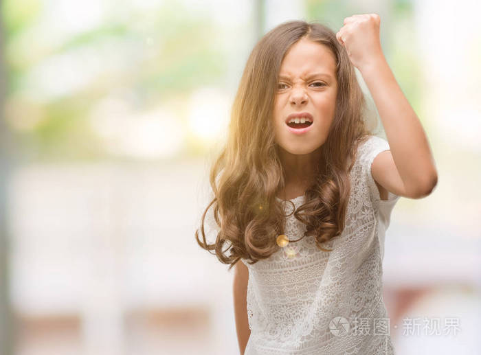 黑发西班牙裔女孩愤怒和疯狂举起拳头沮丧和愤怒, 而愤怒的呼喊.