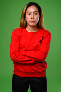 年轻的亚洲妇女的画像反对绿色背景