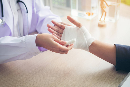 急救和治疗手腕受伤和紊乱, traumatologist 是照顾病人, 女医生包扎
