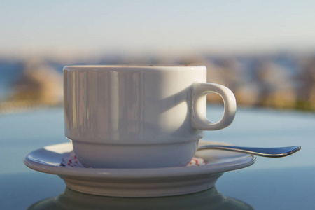 在海上桌上的一杯白咖啡。暑期度假理念