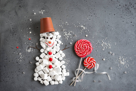 圣诞组合与红色和白色的时令糖果形状的雪人在灰色, 复制空间.