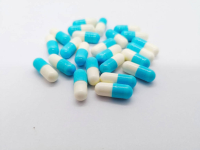 许多白蓝胶囊的消炎痛25毫克隔离在白色背景, 用于缓解疼痛和减少肌肉