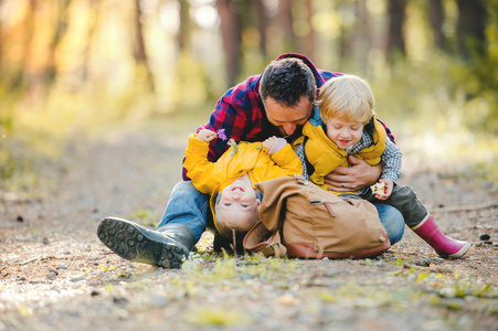 一个成熟的父亲, 背包和幼儿在秋天的森林