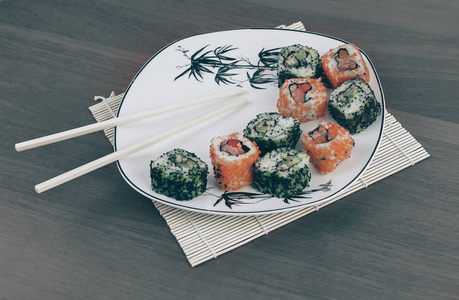 白色盘子上寿司和筷子的特写