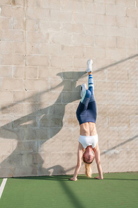 健康的生活方式和瑜伽理念。穿着运动服的女运动员在做运动, 在墙上伸展