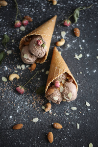 尼斯 designigned chokolate 冰淇淋在 tabble 与坚果和糖 pund 和玫瑰在黑底华夫饼杯