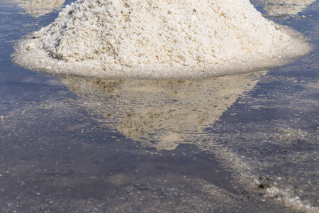 蒸发海水中的原盐或一堆盐;泰国碧武里省的池塘照片
