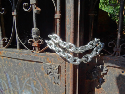 旧的锈迹斑斑的门锁定与闪亮的新银链