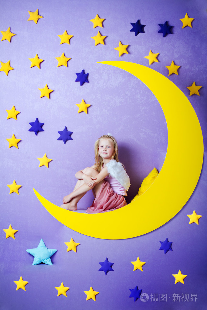 可爱的小女孩坐在一个大的月亮