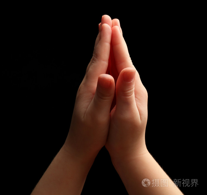 孩子双手放在黑色背景上