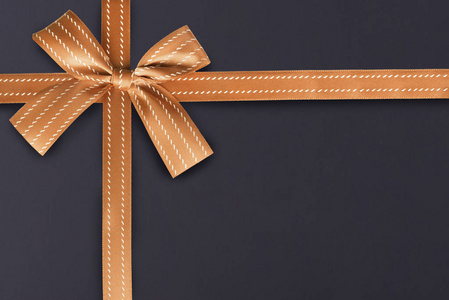 金礼物丝带在黑板上纹理图案在背景。礼品盒包装概念