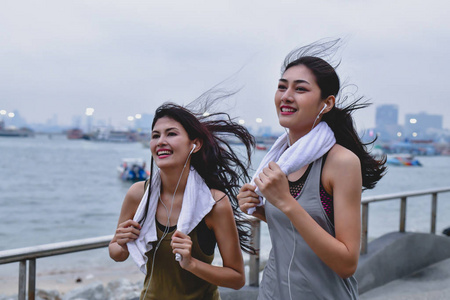 体育概念。美丽的女孩正在海滩上跑步。美丽的女孩是愉快的锻炼