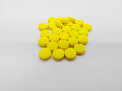 许多黄丸的甲硝唑200毫克在白色背景下分离, 用于治疗细菌感染.