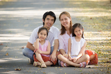 快乐亚洲家庭坐在公园里