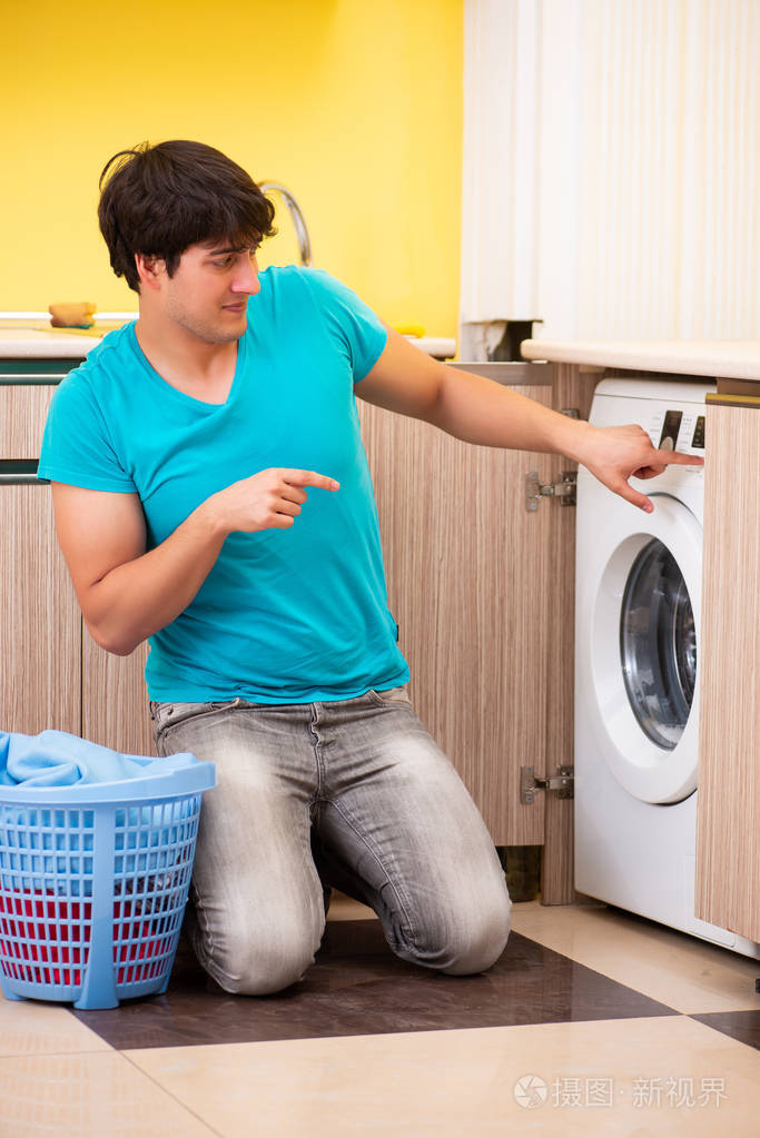 年轻的男人洗衣服在家里