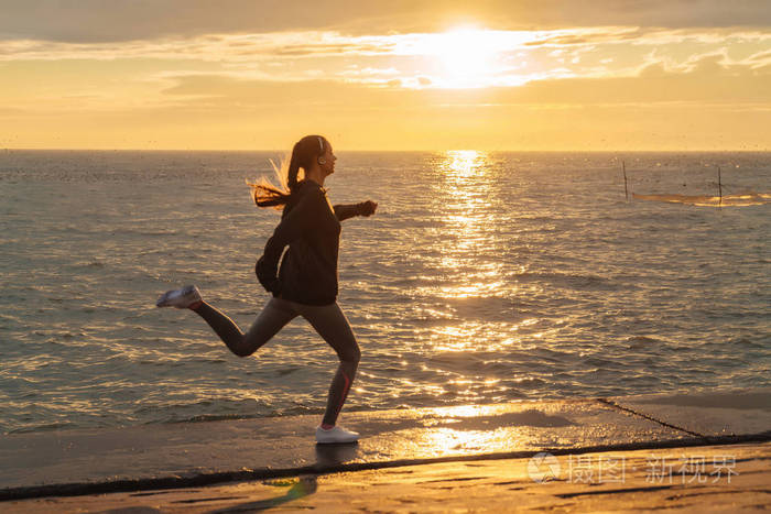 自信快速的女孩在日落时在海边慢跑准备比赛