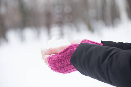 妇女手紧握羊毛手套拿着雪图片
