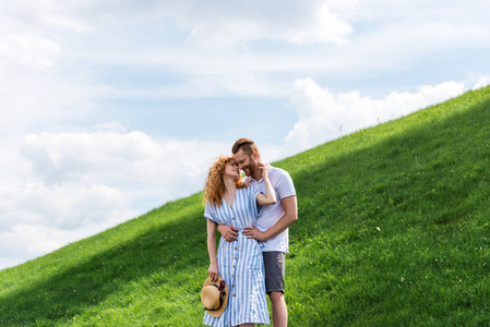 红发夫妇在绿山上互相拥抱