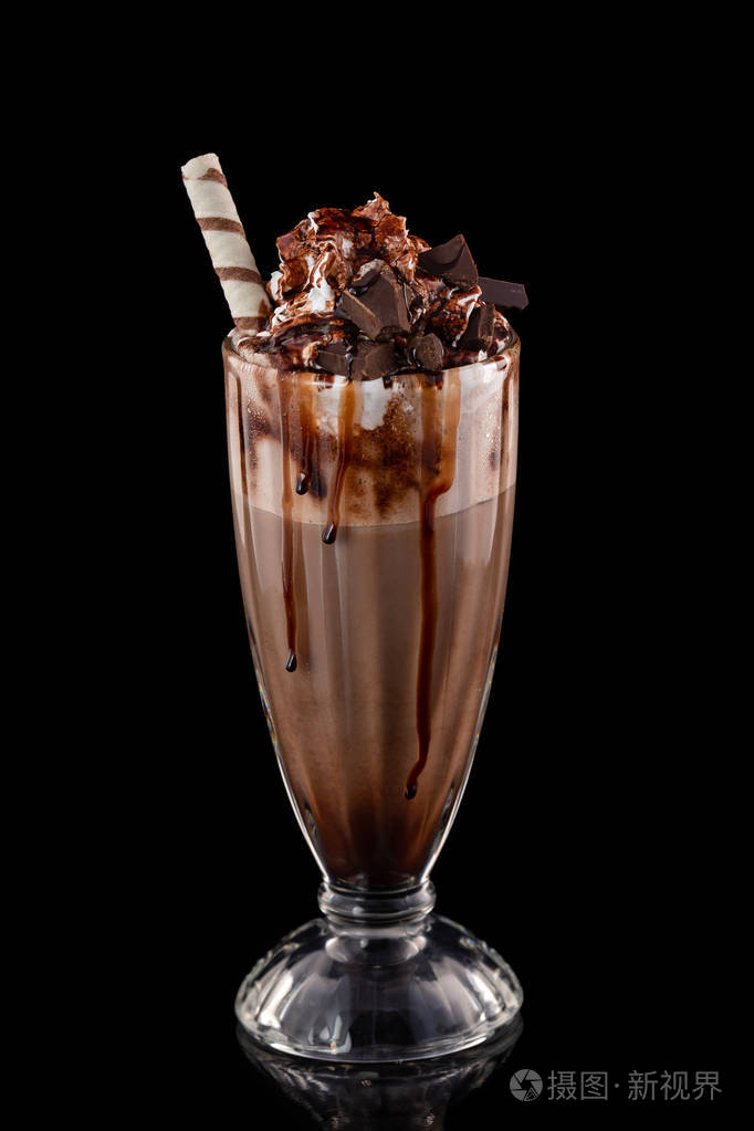 特写玻璃巧克力奶昔装饰焦糖和在黑色背景隔离的奶油