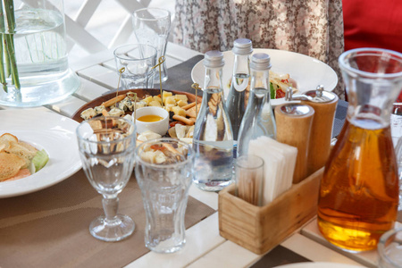 奶酪品种, 蜂蜜, 橄榄油和饼干在质朴的木桌背景