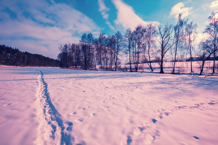 冬天的雪景。晚上, 这条小路被踩在结冰的湖面上。雪地上的脚印