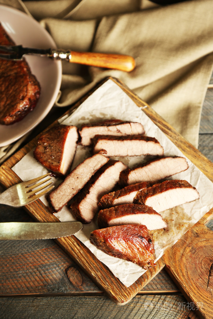 组成与切片烧烤肉在砧板上木制的背景上