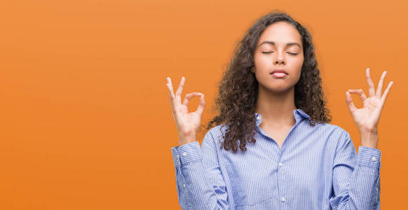 年轻的西班牙商界女性放松和微笑闭上眼睛做冥想手势用手指。瑜伽理念