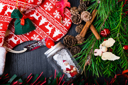 圣诞袜子与礼物, 浆果, 花环, 圣诞老人, 圆锥, 肉桂。挂在木制背景上的圣诞装饰长袜和玩具。顶视图