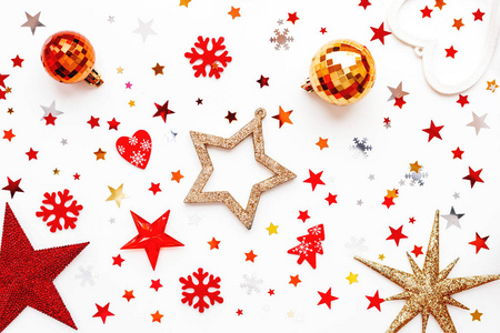 圣诞节和新年假期的背景与装饰。闪亮的红球, 金色的雪花和星状的五彩纸屑。平面布局, 顶部视图