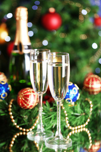 瓶香槟与玻璃和圣诞球圣诞树背景