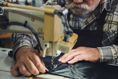 部分视图的男性裁缝工作缝纫机在工作室