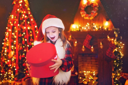 可爱的小女孩，在舒适的客厅里的一棵圣诞树在冬天开放神奇的圣诞礼物