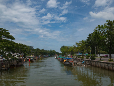 长尾渔船停放在运河, 绿树沿运河与蓝天背景