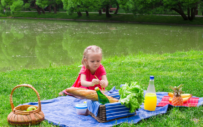 可爱的小女孩在野餐上找到乐趣