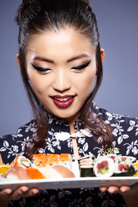 用筷子夹着相机的镜头手持寿司寿司女人