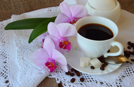 杯咖啡和一个分支的兰花