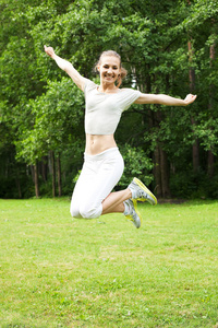 在绿草地上跳跃运动女人