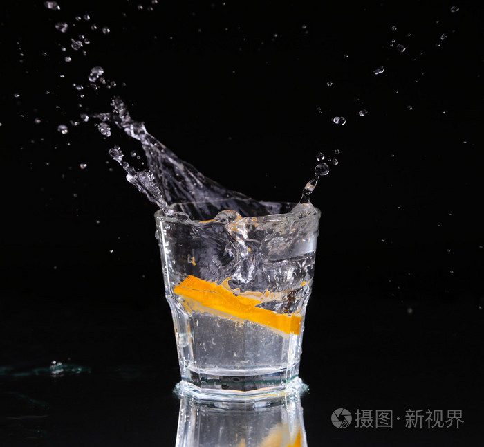 水用一种喷雾的水滴悬浮在一个黑色的背景上的玻璃上面的空气中的运动