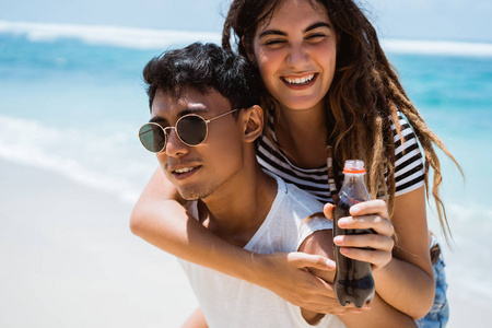 年轻夫妇走与男子背着他们的女人照片