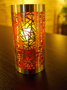 用金属和彩色玻璃制成的创意蜡烛架在餐厅的桌子上发光