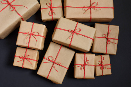 给朋友和家人的礼物。堆的箱子。手工纸包装和红绳弓中的礼物选择