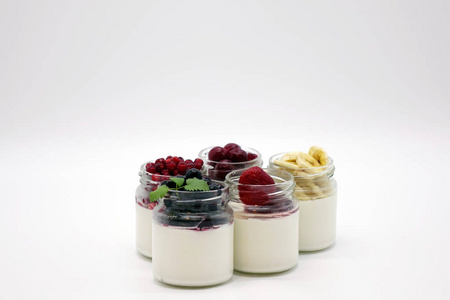 罐子里有新鲜的浆果和酸奶。在白色背景